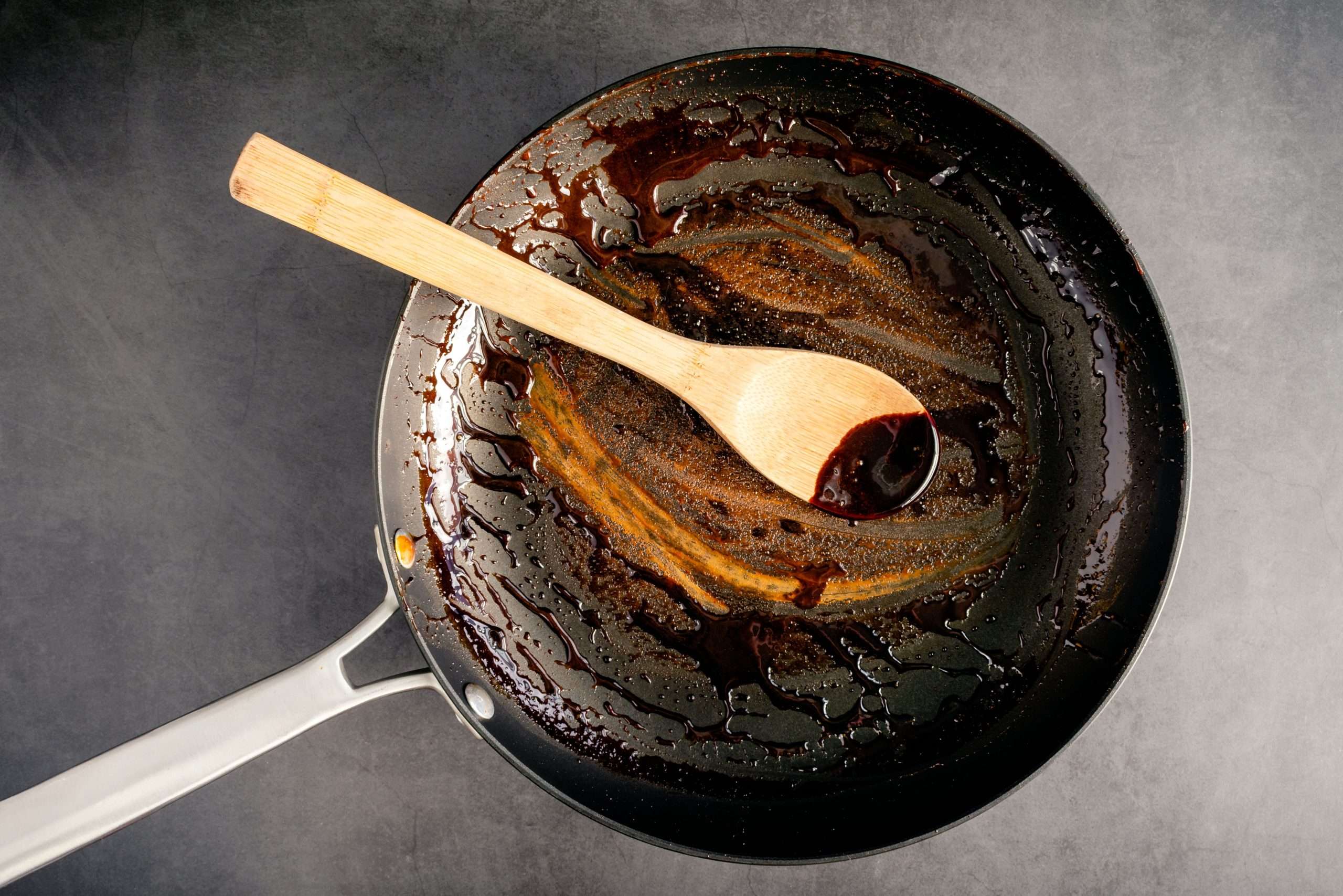dirty-nonstick-skillet-and-wooden-spoon-used-to-make-a-balsamic-reduction-1366843720-eaaea6df5ff64a899231593bb2a240e0
