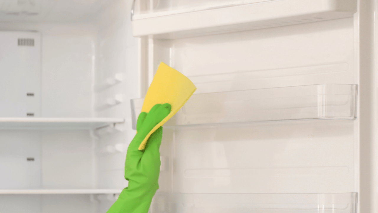 A woman using a rag to clean both inside and outside of the oven.