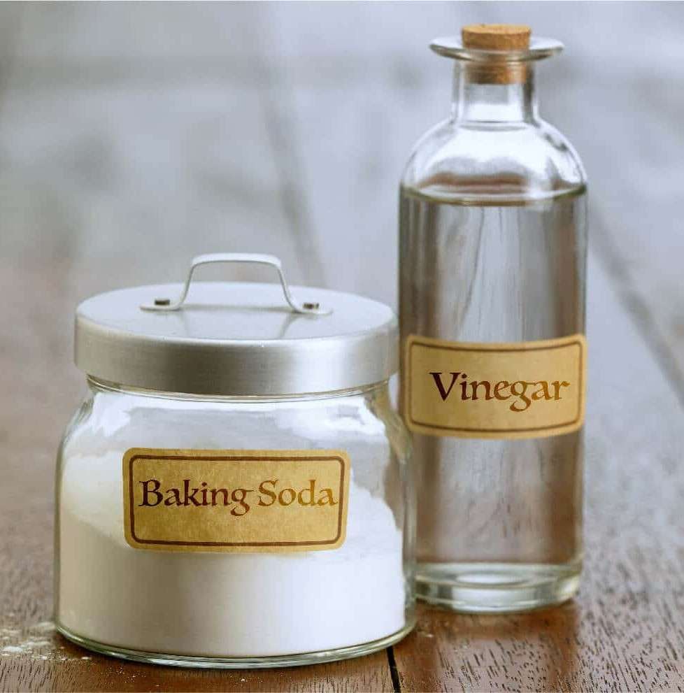 Jar-of-baking-soda-and-bottle-of-vinegar-on-a-table